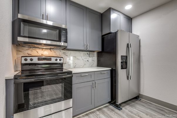 Interior, Kitchen, Marble Walls, Recessed Lighting, Stainless Steel Appliances, Wood Texture Flooring