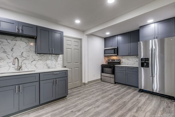Interior, Kitchen, Marble Walls, Recessed Lighting, Stainless Steel Appliances, Wood Texture Flooring