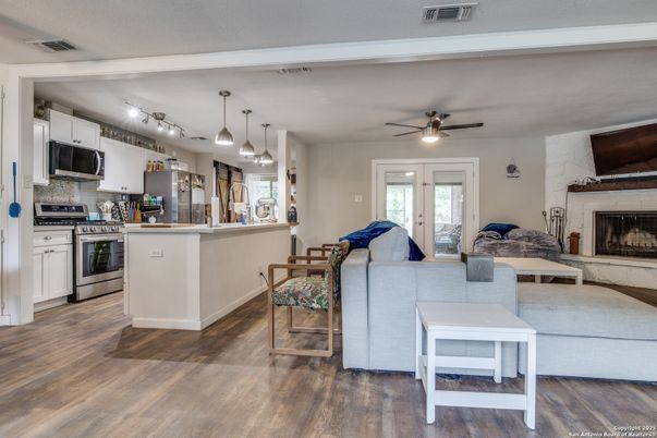 Dining room, Fireplace, Interior, Kitchen, Living room, Pendant Lights, Stainless Steel Appliances, Wood Texture Flooring