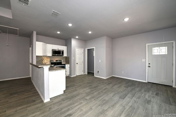 Empty room, Interior, Kitchen, Recessed Lighting, Stainless Steel Appliances, Wood Texture Flooring