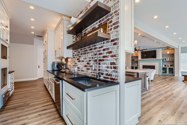Fireplace, Interior, Kitchen, Pendant Lights, Recessed Lighting, Stainless Steel Appliances, Stone Walls, Wood Texture Flooring