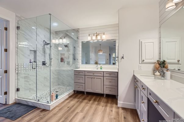 Bathroom, Dual Sink Vanities, Glass Shower, Interior, Marble Walls, Recessed Lighting, Wood Texture Flooring