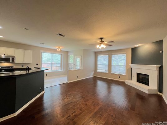 Empty room, Fireplace, Interior, Kitchen, Recessed Lighting, Stainless Steel Appliances, Wood Texture Flooring