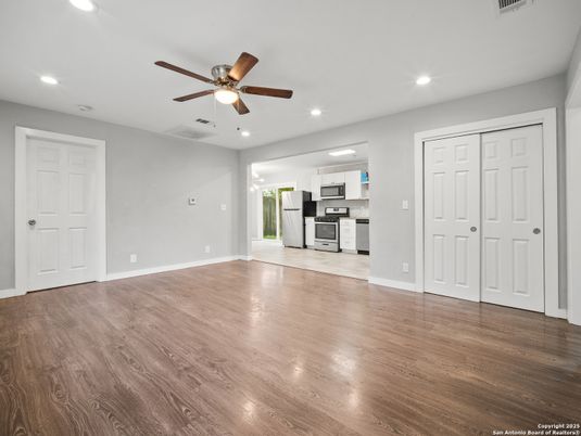 Empty room, Interior, Kitchen, Recessed Lighting, Stainless Steel Appliances, Wood Texture Flooring