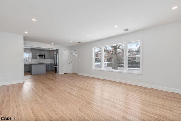 Empty room, Interior, Kitchen, Recessed Lighting, Stainless Steel Appliances, Wood Texture Flooring