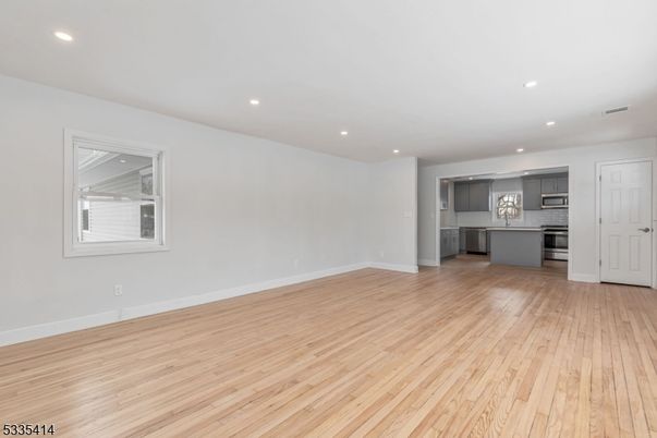 Empty room, Interior, Kitchen, Recessed Lighting, Stainless Steel Appliances, Wood Texture Flooring