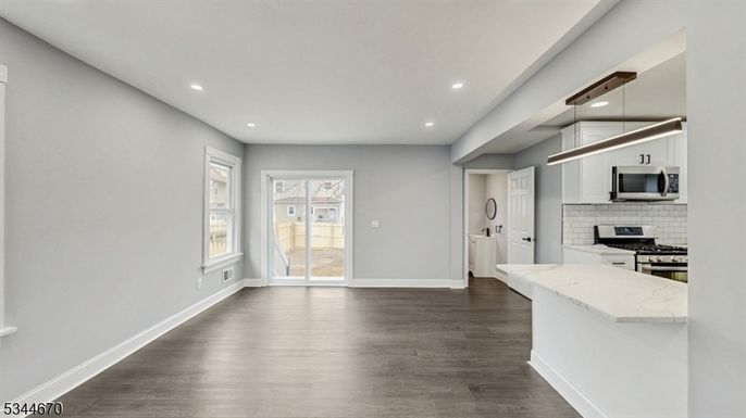 Empty room, Interior, Kitchen, Pendant Lights, Recessed Lighting, Stainless Steel Appliances, Wood Texture Flooring
