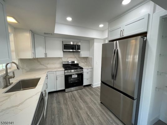 Interior, Kitchen, Marble Walls, Recessed Lighting, Stainless Steel Appliances, Wood Texture Flooring