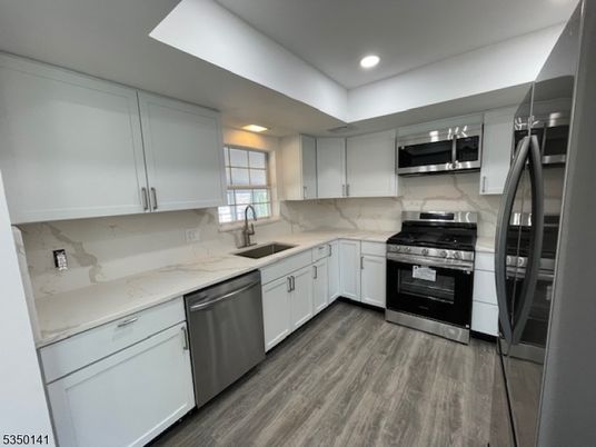 Interior, Kitchen, Marble Walls, Recessed Lighting, Stainless Steel Appliances, Wood Texture Flooring