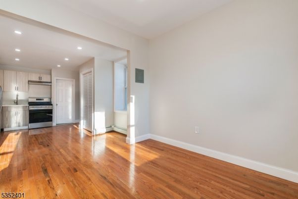 Empty room, Interior, Kitchen, Recessed Lighting, Stainless Steel Appliances, Wood Texture Flooring