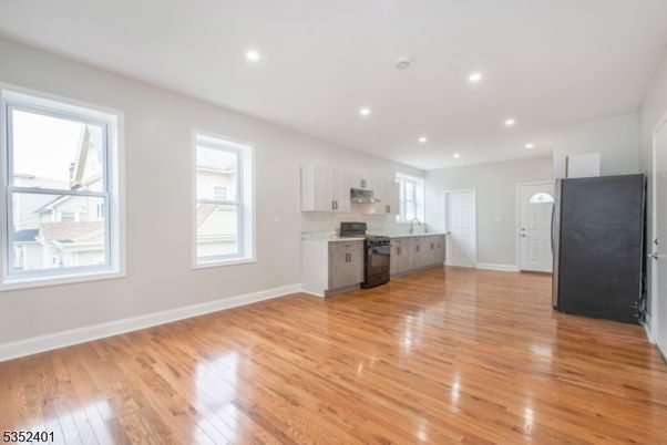 Empty room, Interior, Kitchen, Recessed Lighting, Stainless Steel Appliances, Wood Texture Flooring