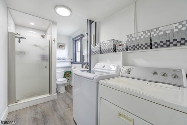 Bathroom, Glass Shower, Interior, Recessed Lighting, Washer, Wood Texture Flooring