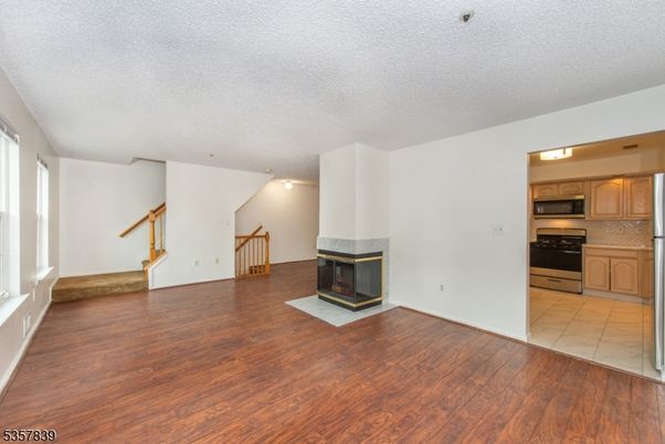 Empty room, Fireplace, Interior, Kitchen, Stainless Steel Appliances, Wood Texture Flooring