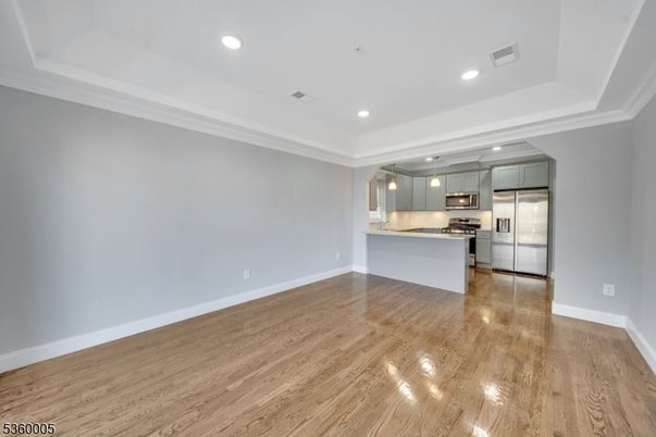 Empty room, Interior, Kitchen, Pendant Lights, Recessed Lighting, Stainless Steel Appliances, Wood Texture Flooring