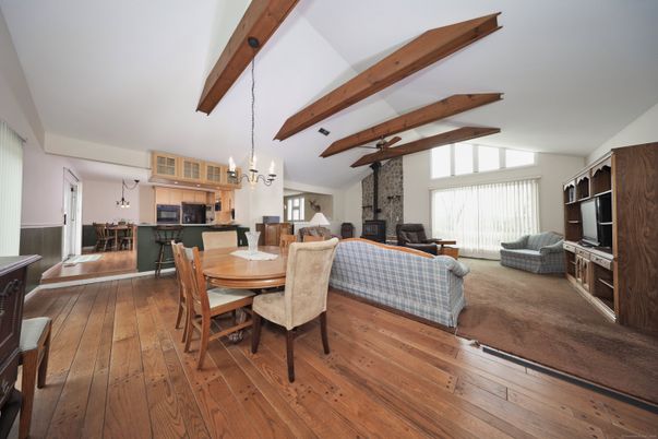 Chandelier, Dining room, Fireplace, Interior, Kitchen, Living room, Pendant Lights, Stainless Steel Appliances, Stone Walls, Wooden Beams, Wood Texture Flooring