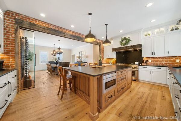 Chandelier, Dining room, Interior, Kitchen, Pendant Lights, Recessed Lighting, Stainless Steel Appliances, Stone Walls, Wood Texture Flooring