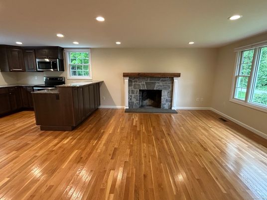 Empty room, Fireplace, Interior, Kitchen, Recessed Lighting, Stainless Steel Appliances, Wood Texture Flooring