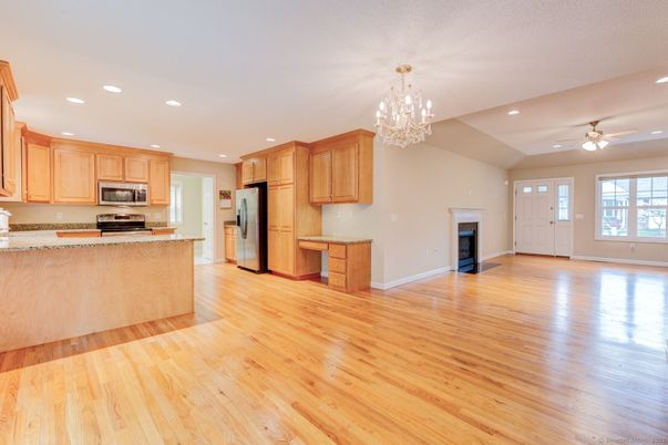 Chandelier, Empty room, Fireplace, Interior, Kitchen, Recessed Lighting, Stainless Steel Appliances, Wood Texture Flooring