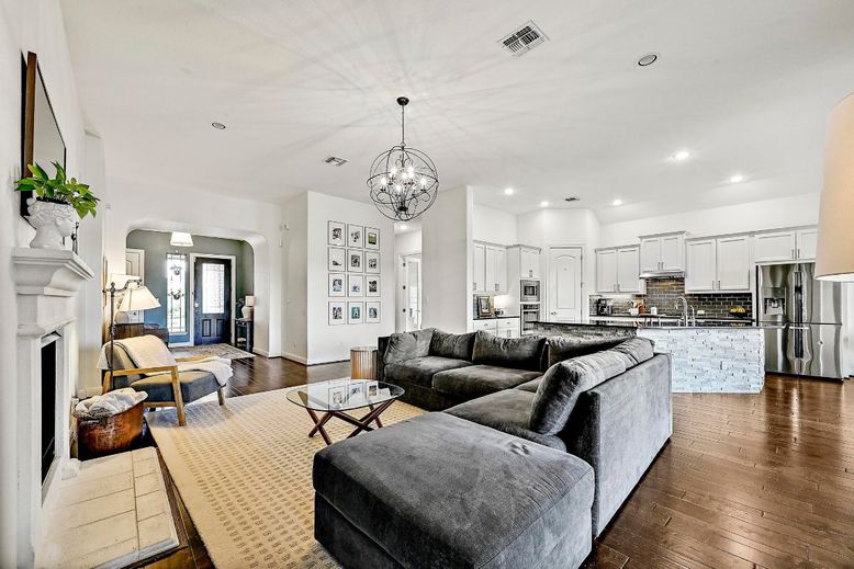 Chandelier, Fireplace, Interior, Kitchen, Living room, Pendant Lights, Recessed Lighting, Stainless Steel Appliances, Wood Texture Flooring