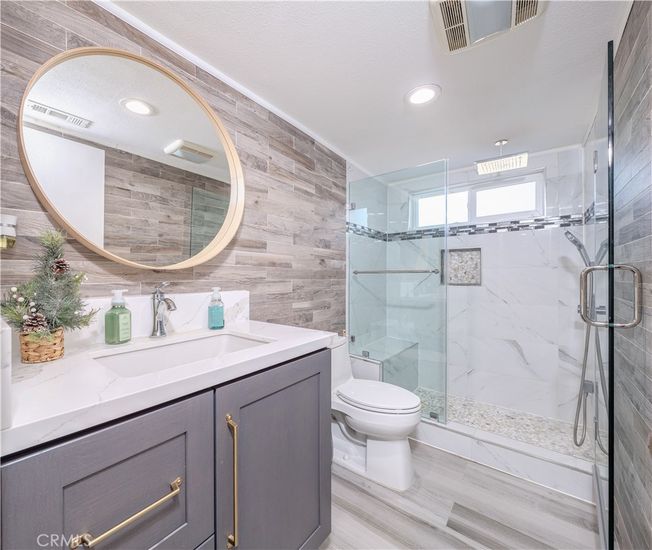 Bathroom, Dual Sink Vanities, Glass Shower, Interior, Marble Walls, Recessed Lighting, Wood Texture Flooring, Wooden Walls