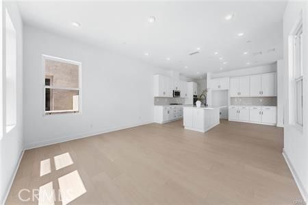 Empty room, Interior, Kitchen, Recessed Lighting, Stainless Steel Appliances, Wood Texture Flooring