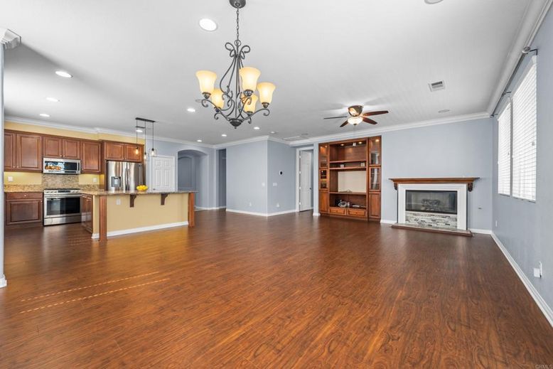 Chandelier, Empty room, Fireplace, Interior, Kitchen, Recessed Lighting, Stainless Steel Appliances, Wood Texture Flooring