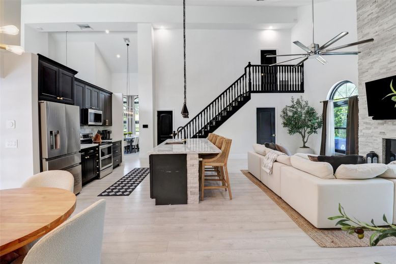 Fireplace, Interior, Kitchen, Living room, Pendant Lights, Recessed Lighting, Stainless Steel Appliances, Stone Walls, Wood Texture Flooring