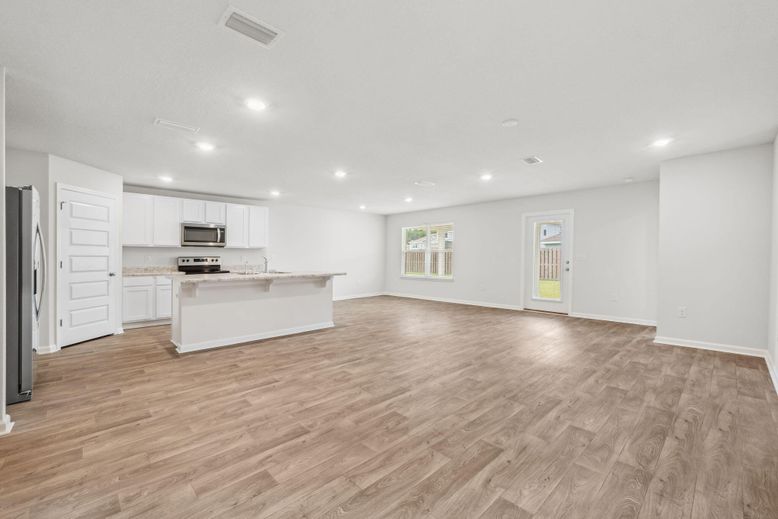 Empty room, Interior, Kitchen, Recessed Lighting, Stainless Steel Appliances, Wood Texture Flooring