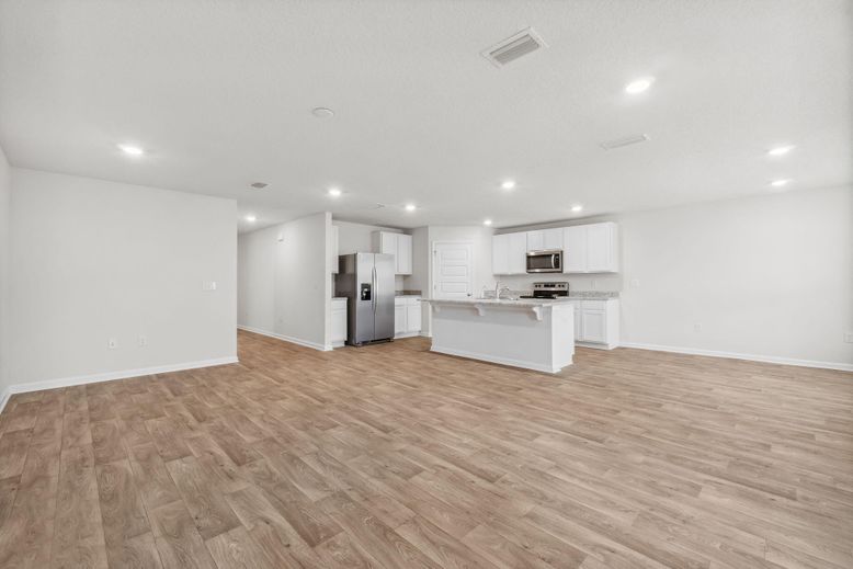 Empty room, Interior, Kitchen, Recessed Lighting, Stainless Steel Appliances, Wood Texture Flooring