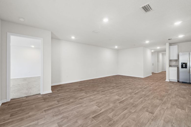 Empty room, Interior, Kitchen, Recessed Lighting, Stainless Steel Appliances, Wood Texture Flooring