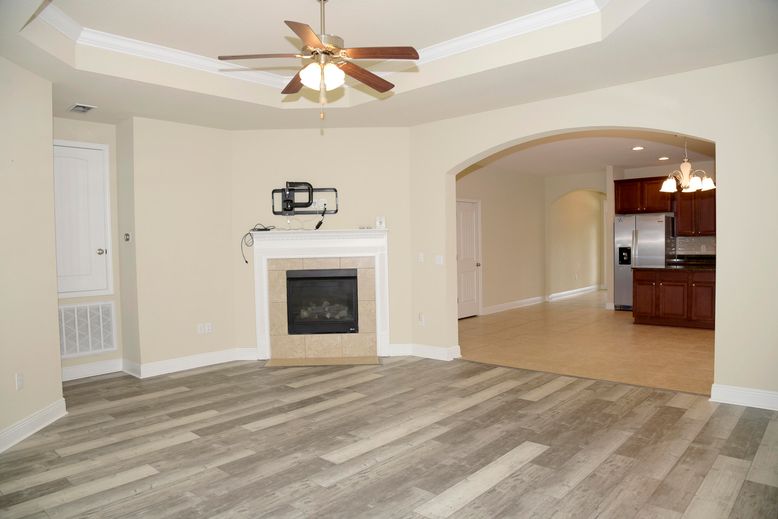 Chandelier, Empty room, Fireplace, Interior, Kitchen, Pendant Lights, Recessed Lighting, Stainless Steel Appliances, Wood Texture Flooring