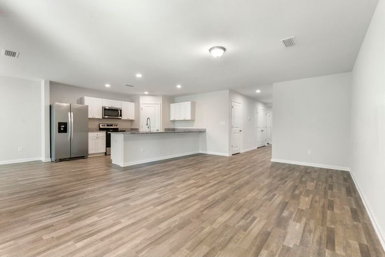 Empty room, Interior, Kitchen, Recessed Lighting, Stainless Steel Appliances, Wood Texture Flooring