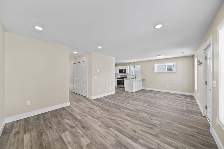 Empty room, Interior, Kitchen, Recessed Lighting, Stainless Steel Appliances, Wood Texture Flooring