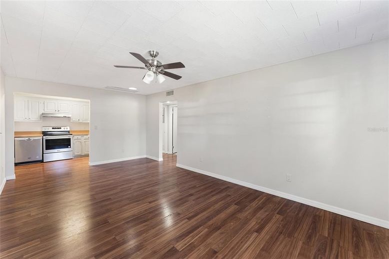 Empty room, Interior, Kitchen, Recessed Lighting, Stainless Steel Appliances, Wood Texture Flooring