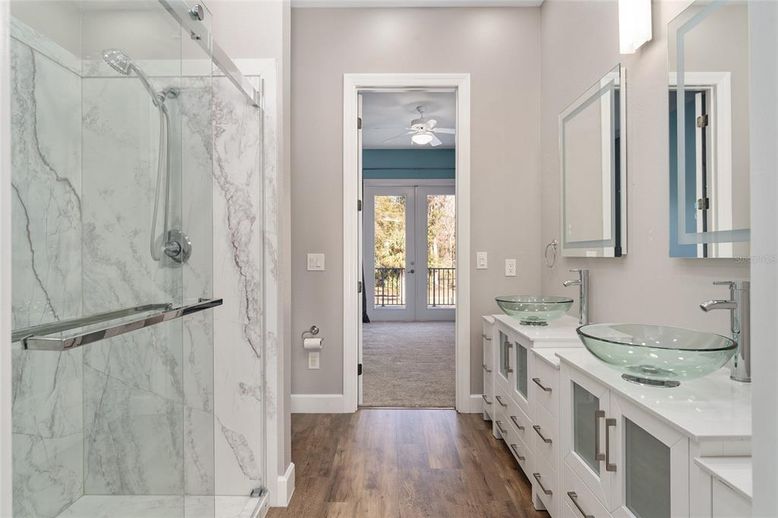 Bathroom, Dual Sink Vanities, Glass Shower, Interior, Marble Walls, Wood Texture Flooring