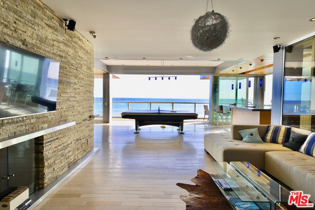 Billiard Table, Fireplace, Game Room, Interior, Living room, Pendant Lights, Recessed Lighting, Stone Walls, Water, Wood Texture Flooring